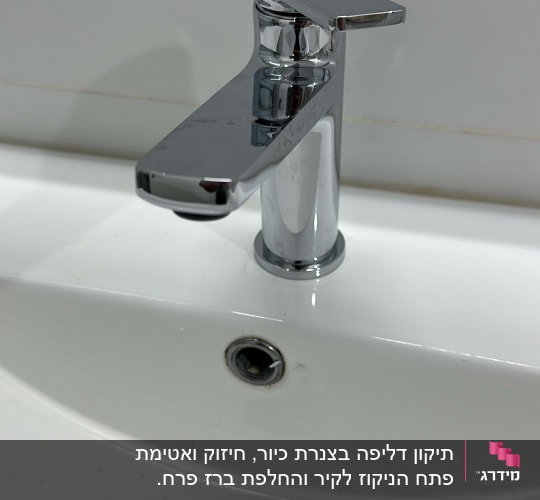 ברז כרום מותקן על כיור לבן עם ניקוז